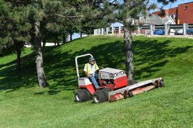 Landscape worker mowing lawn