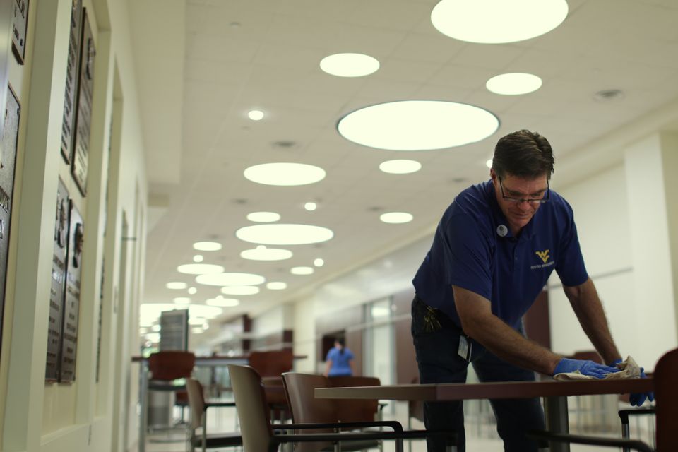 WVU facilities worker cleans tables